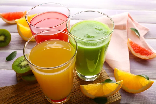 Jugos frescos con frutas en mesa de madera —  Fotos de Stock