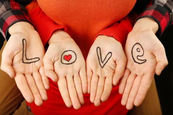 Mãos de casal com inscrição Amor, close-up view — Fotografia de Stock