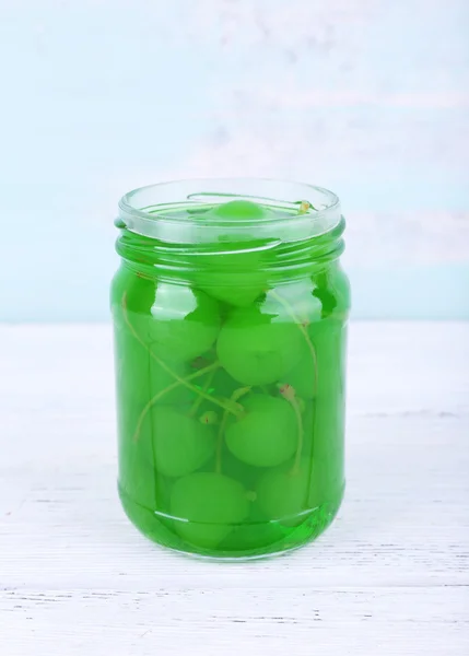 Zelfgemaakte pot groene maraschino kers op houten tafel en kleur muur achtergrond — Stockfoto