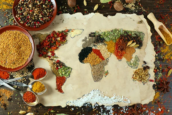 Map of world made from different kinds of spices on wooden background — Stock Photo, Image