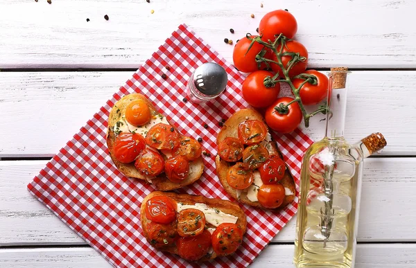 Slices of white toasted bread with butter and canned tomatoes on wooden background — Stock Photo, Image