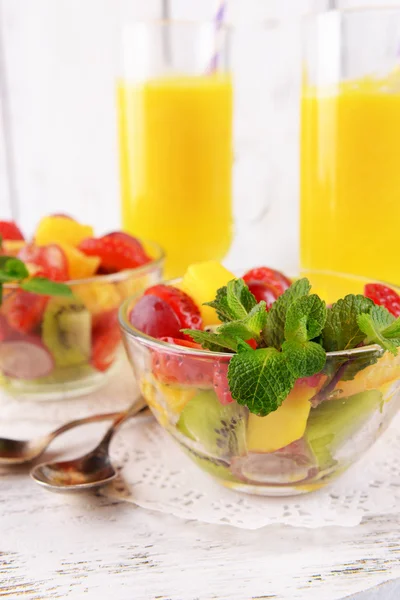 Fruktsallad med mynta och apelsinjuice i glas på färg trä bakgrund — Stockfoto