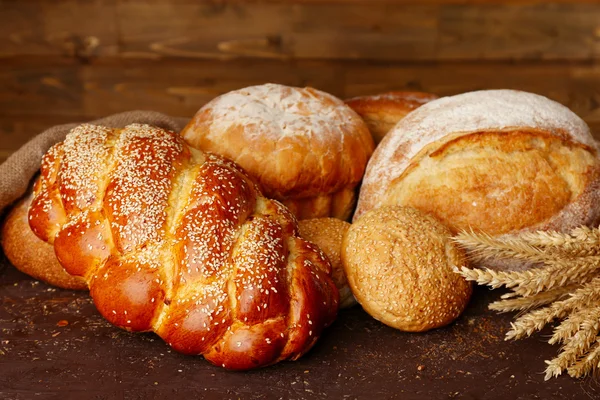 Ahşap arka plan üzerinde kulakları ile farklı ekmek — Stok fotoğraf