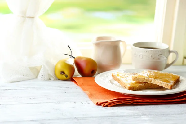 Tostadas con miel en plato con taza de té sobre fondo brillante — Foto de Stock