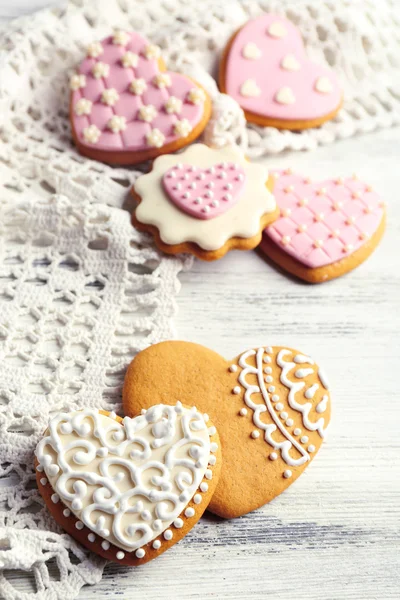 Biscotti a forma di cuore per il giorno di San Valentino sul tovagliolo, su sfondo di legno a colori — Foto Stock