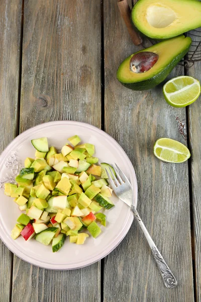 Insalata con mela e avocado su piatto con lime su fondo di legno — Foto Stock