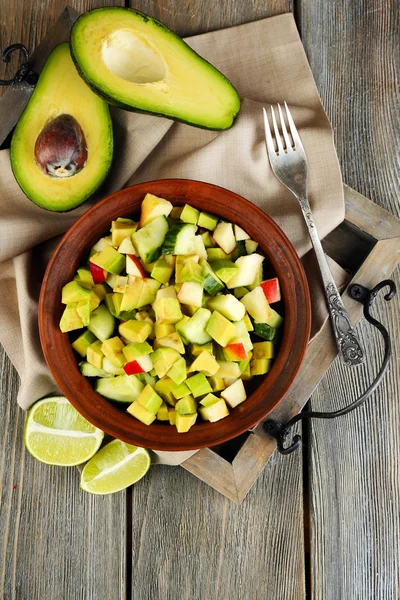 Ensalada con manzana y aguacate en tazón en bandeja sobre mesa de cerca — Foto de Stock