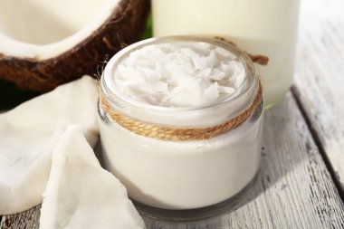 Cam renk ahşap masa arka plan üzerinde taze hindistan cevizi yağı