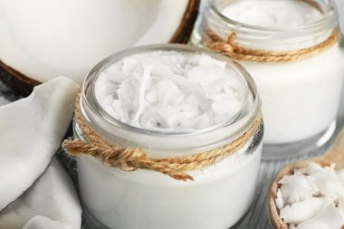 Züccaciye Mağazaları ve tahta kaşık renk ahşap masa arka plan üzerinde taze hindistan cevizi yağı