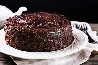 Lezzetli çikolatalı pasta plaka koyu arka plan üzerinde ahşap tablo