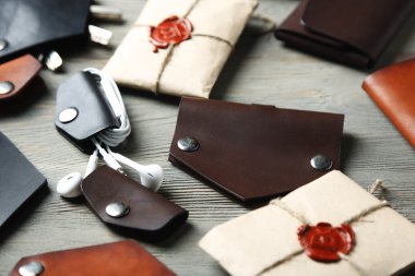 Tahta arka planda farklı el yapımı deri adam aksesuarları.