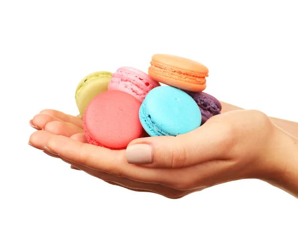 Tasty colorful macaroons in female hands isolated on white — Stock Photo, Image