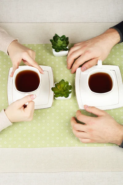 Female and male hands with cups of tea, close-up — Stock Photo, Image