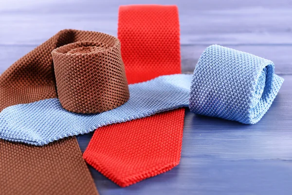 Bunte männliche Krawatten auf farbigem Holztischhintergrund — Stockfoto