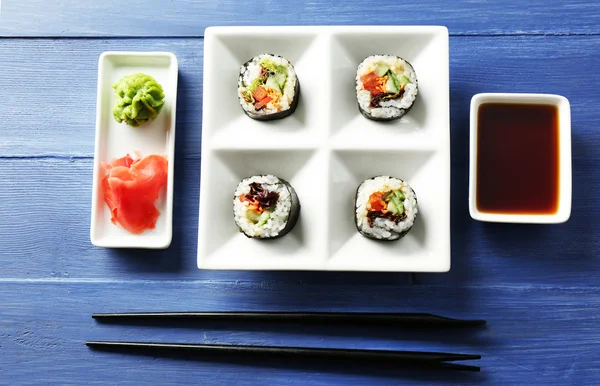 Rollos de sushi vegetal en plato sobre fondo de madera de color — Foto de Stock