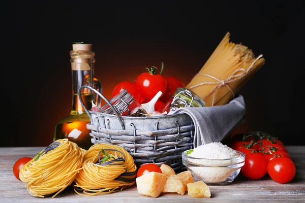 Massa com tomate cereja e outros ingredientes sobre fundo escuro — Fotografia de Stock