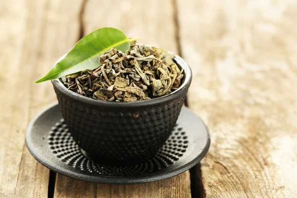 Green tea with leaf in cup on old wooden table — Stock Photo, Image
