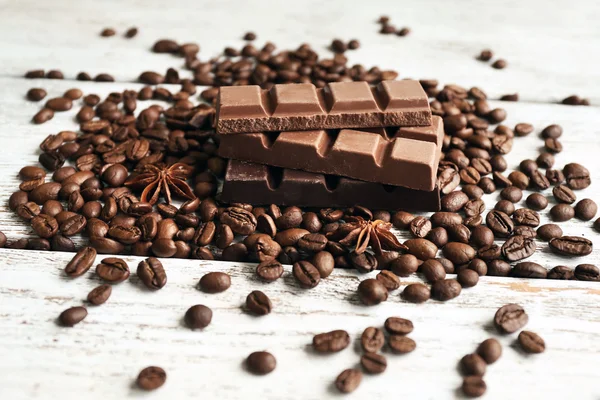 Chocolate con anís estrellado y granos de café sobre fondo de madera — Foto de Stock