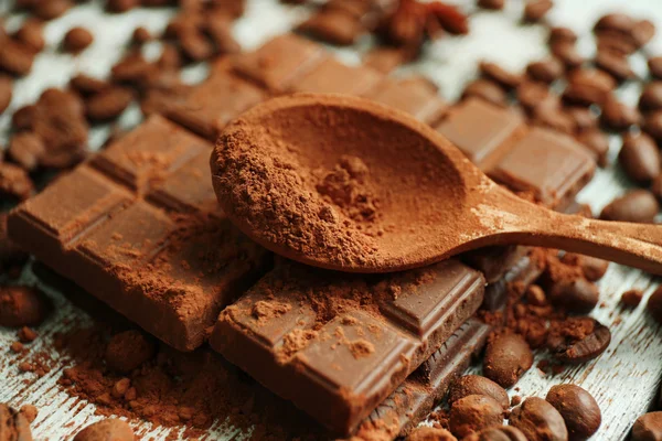 Still life with chocolate, grains and cocoa on wooden background — Stock Photo, Image