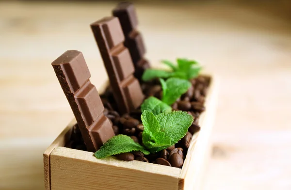 Bodegón con set de chocolate en caja de madera de granos de café sobre fondo de madera — Foto de Stock
