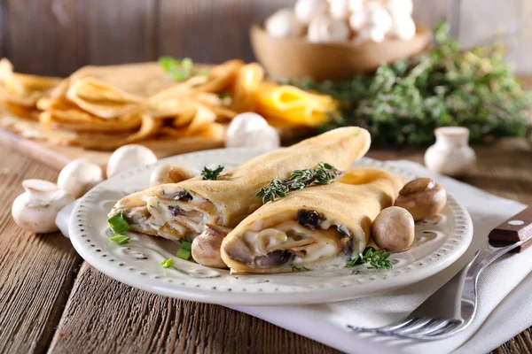 Panqueques con champiñones cremosos en plato sobre fondo de madera —  Fotos de Stock