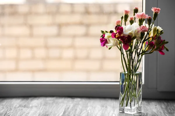 Hermosas flores de primavera en jarrón de vidrio sobre fondo de alféizar de ventana —  Fotos de Stock