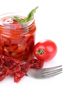 Cam Kavanoz ve taze domates fesleğen yaprakları üzerinde beyaz izole ile güneş kurutulmuş domates