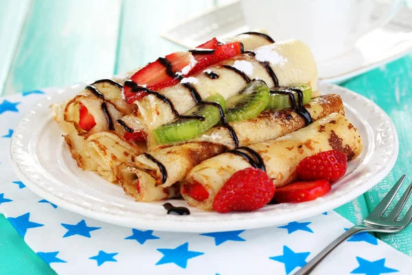 Deliziose frittelle con fragole e cioccolato sul piatto sul tavolo — Foto Stock