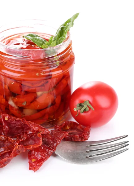 Sun dried tomatoes in glass jar and fresh tomatoes with basil leaves isolated on white — Stock Photo, Image