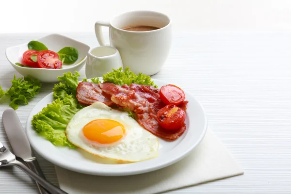 Bacon and eggs on color wooden table background — Stock Photo, Image