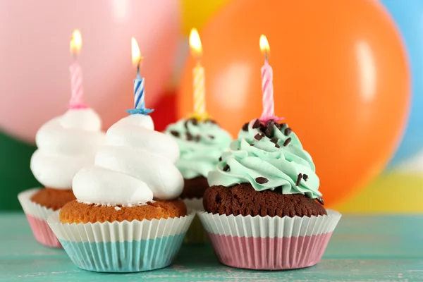 Deliciosos cupcakes de cumpleaños en la mesa sobre un fondo brillante — Foto de Stock