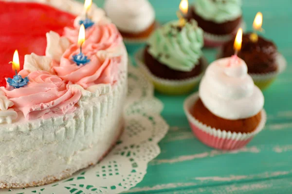 Délicieux gâteau d'anniversaire avec des cupcakes sur fond en bois — Photo