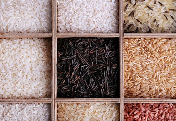 Různé typy rýže v dřevěné krabici — Stock fotografie