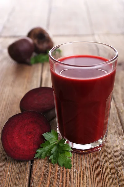 Glas av betor juice med rödbetor på träbord nära håll — Stockfoto
