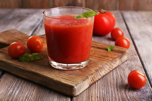 Glas tomatjuice med körsbärstomater på träbord nära håll — Stockfoto