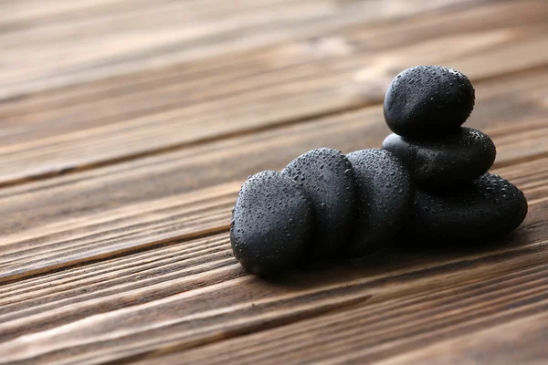 Spa stones with water drops on wooden background — Stock Photo, Image