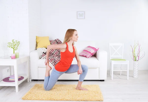 Mujer joven haciendo yoga en casa — Foto de Stock