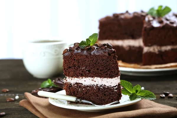 Delicioso bolo de chocolate na mesa no fundo claro — Fotografia de Stock