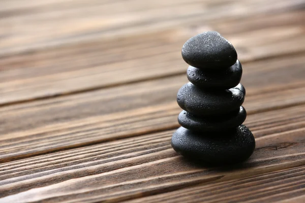 Spa stones with water drops on wooden background — Stock Photo, Image