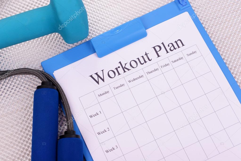 Workout plan and sports equipment top view close-up 