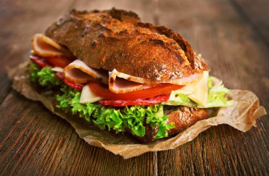 Jambon ve Kağıt ahşap arka plan üzerinde sebze taze ve lezzetli sandviç