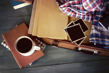 Vintage çanta giysi ve kitaplar ahşap arka plan üzerine açık