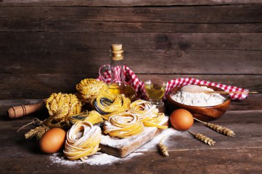 Still life of preparing pasta on rustic wooden background clipart
