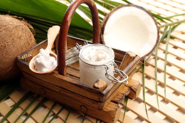 Hindistan cevizi yaprakları ve ahşap zemin üzerine kavanoz içinde Hindistan cevizi yağı ile