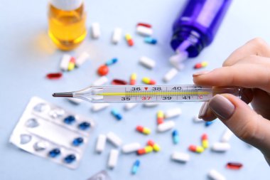 Termometre hapları arka planda tutan el