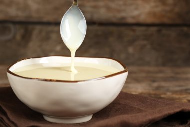 Peçete ahşap zemin üzerine yoğunlaştırılmış süt ile kase