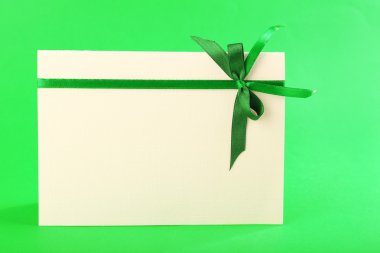 Yeşil arka plan üzerinde yay ile dekore edilmiş kartı