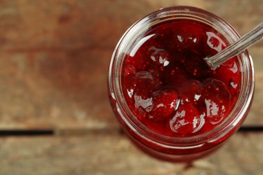 Kavanoz ahşap zemin üzerine kaşıkla çilek reçeli