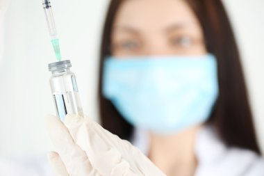 Ampul ve doktorun elinde şırınga