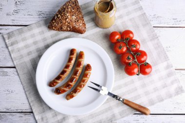 Ekmek ile plaka üzerinde ızgara sosis ve domates tablo üzerinde kapat